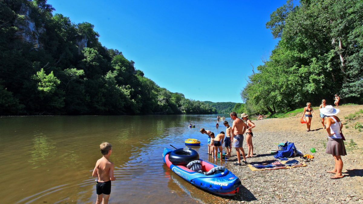 Canoë et vacanciers au bord de la rivière Dordogne.